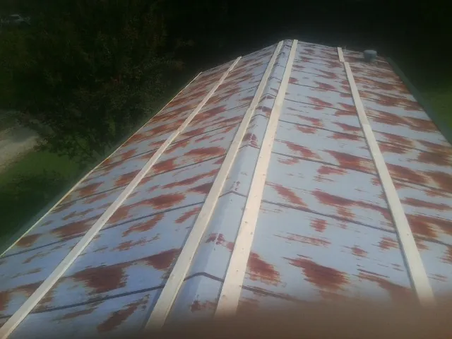 Rusted metal roof panels with new wood purlins before replacement — Storm Damage Roof Repair in West Valley City by Roofing Brothers