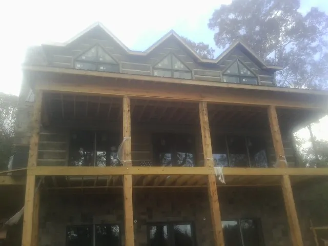 Dormers and porch framing on a large log home under construction — Roof Coating work by our crew in West Valley City