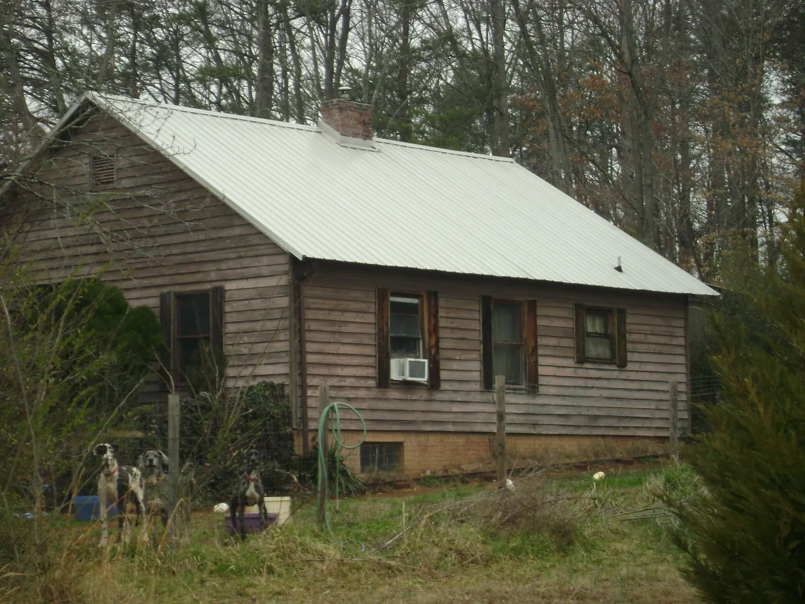 White metal roof on an old wood sided farmhouse, from a Asphalt Shingle Roof Repair job in West Valley City